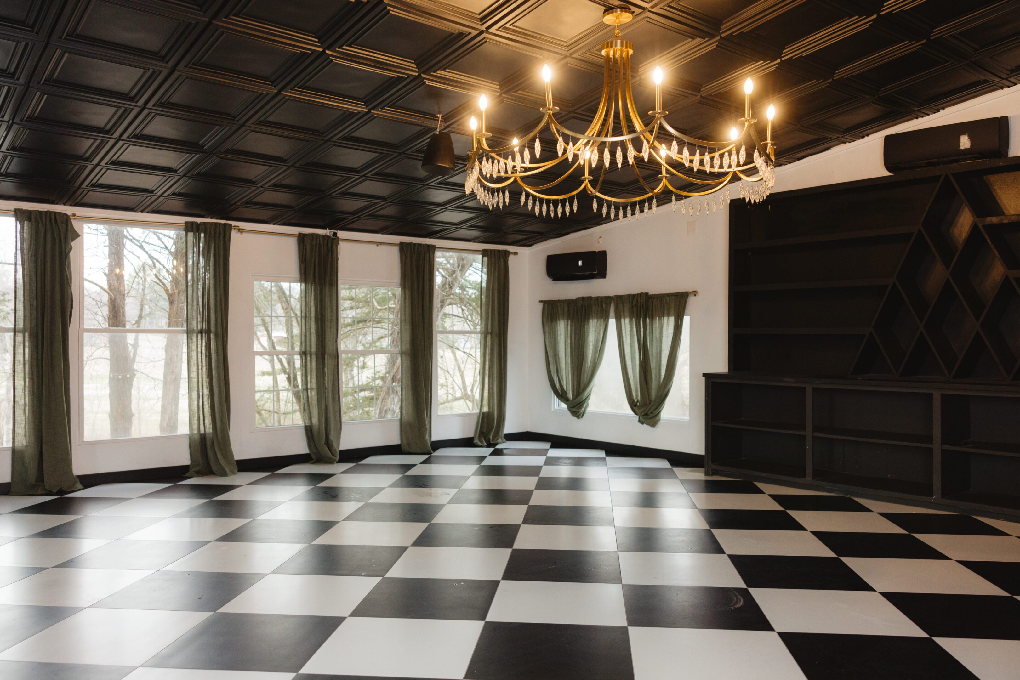 Elegant room with checkered floor and chandelier lighting.