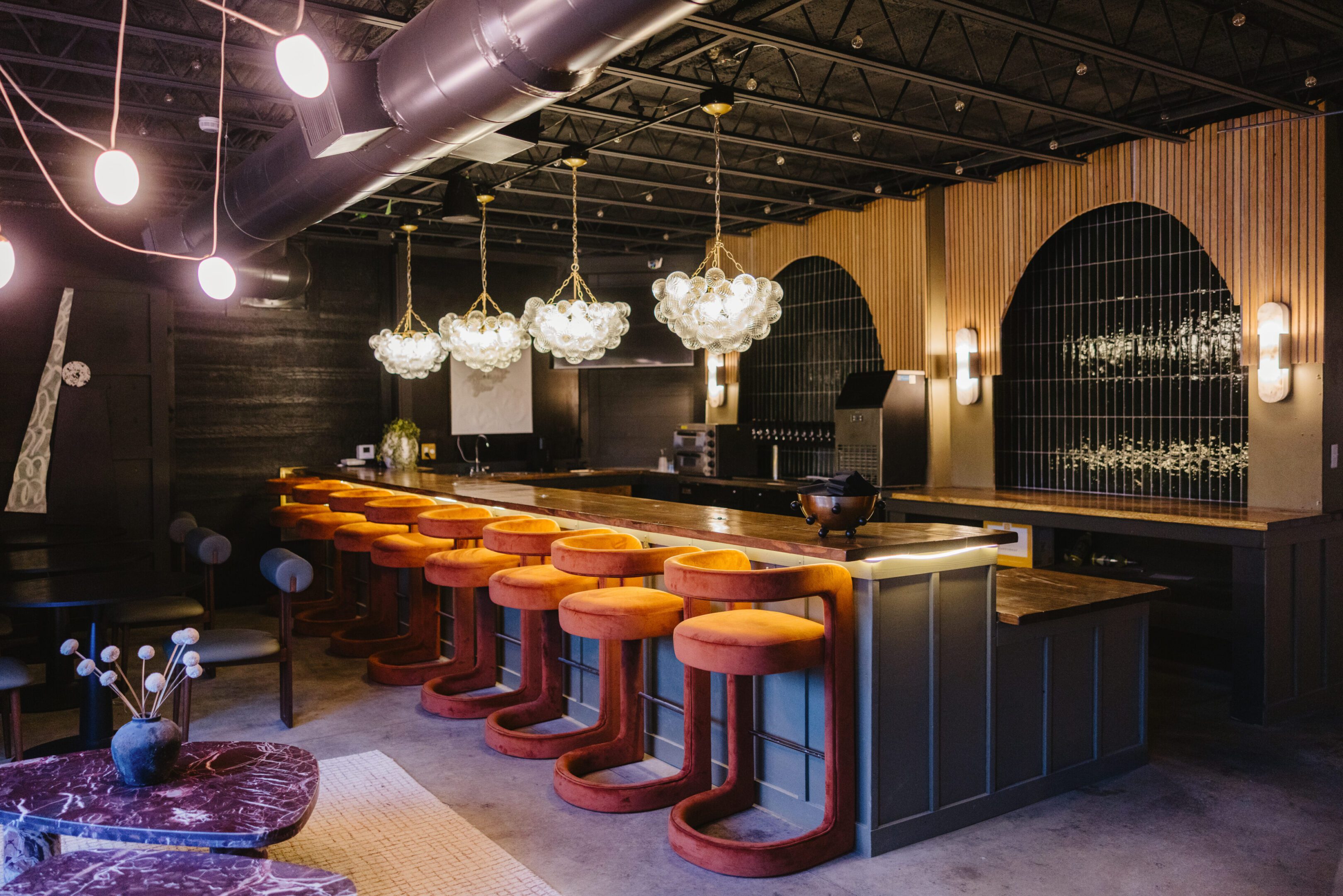 Stylish bar with retro stools and elegant hanging lights.