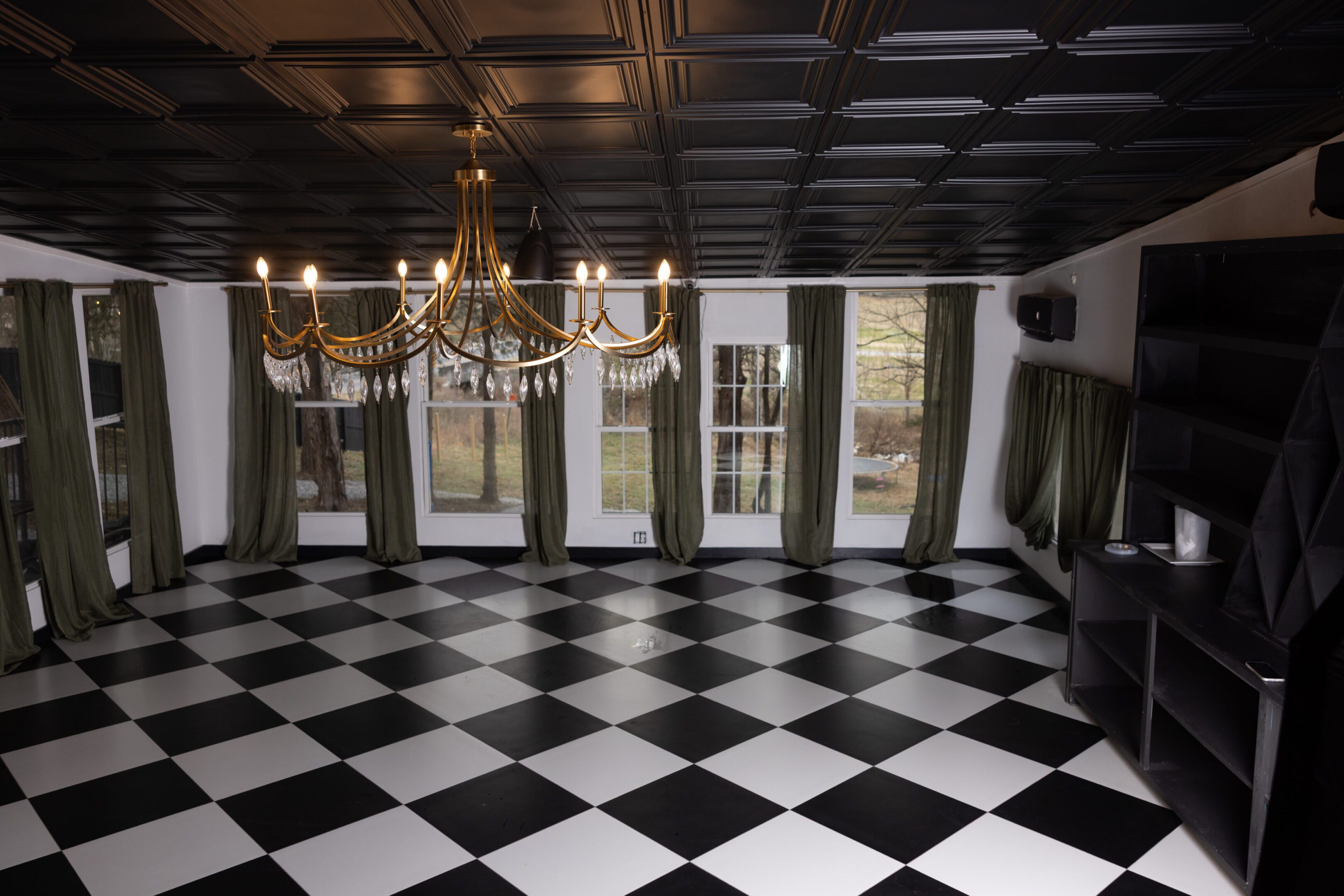 Elegant room with black-and-white checkered floor and gold chandelier.