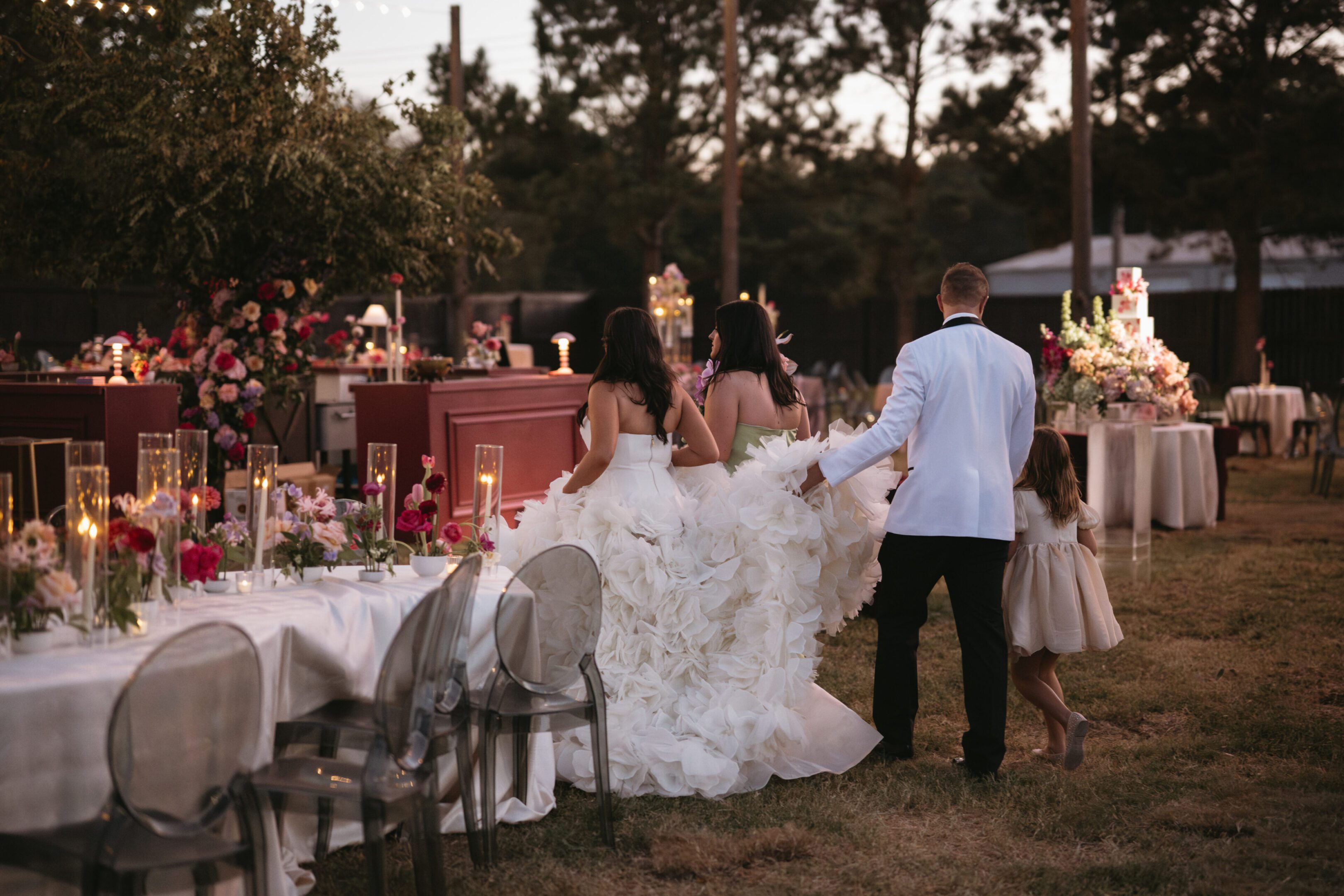 Couple walking hand-in-hand at an elegant outdoor wedding reception.