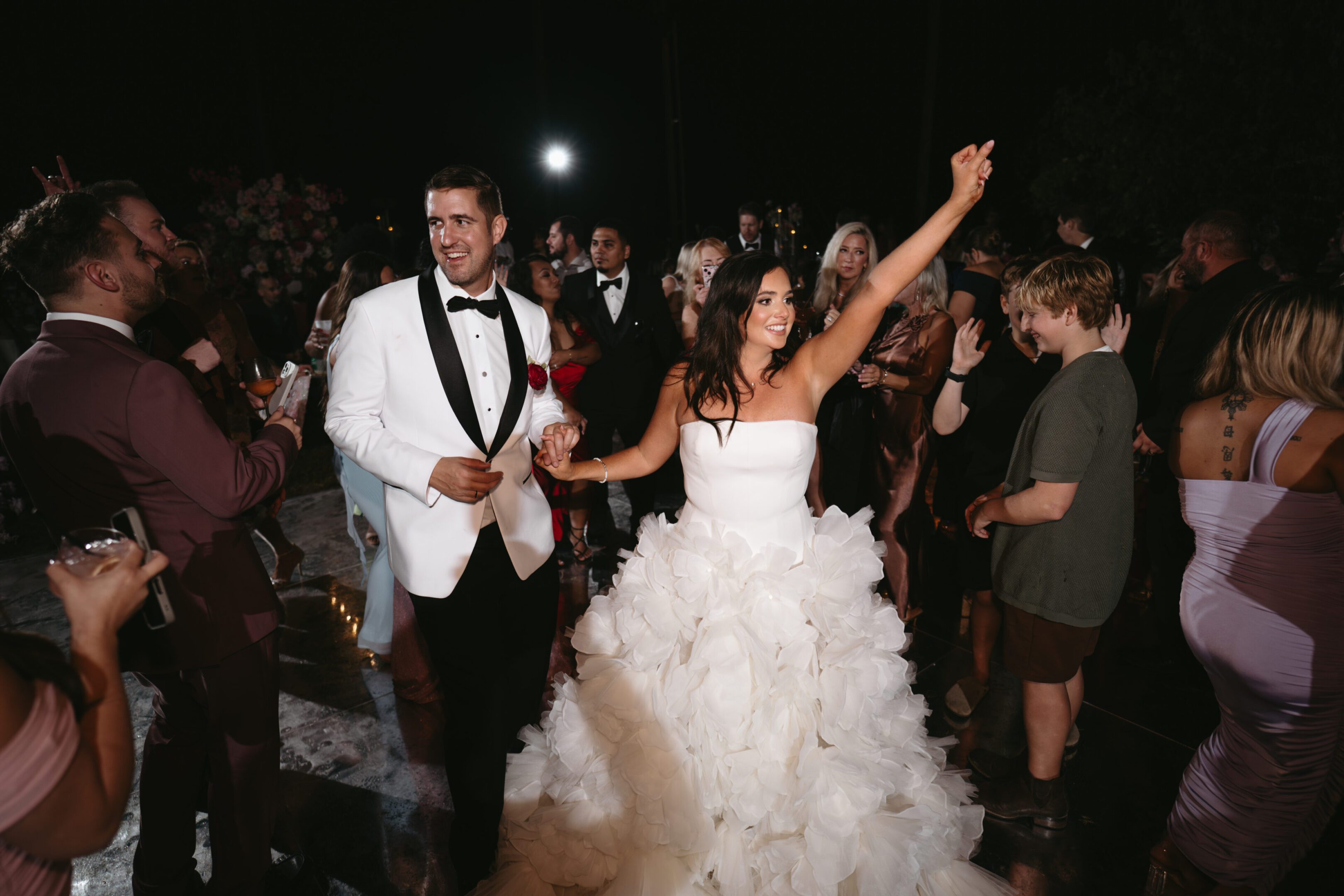 Bride and groom joyfully celebrating their wedding night outdoors.