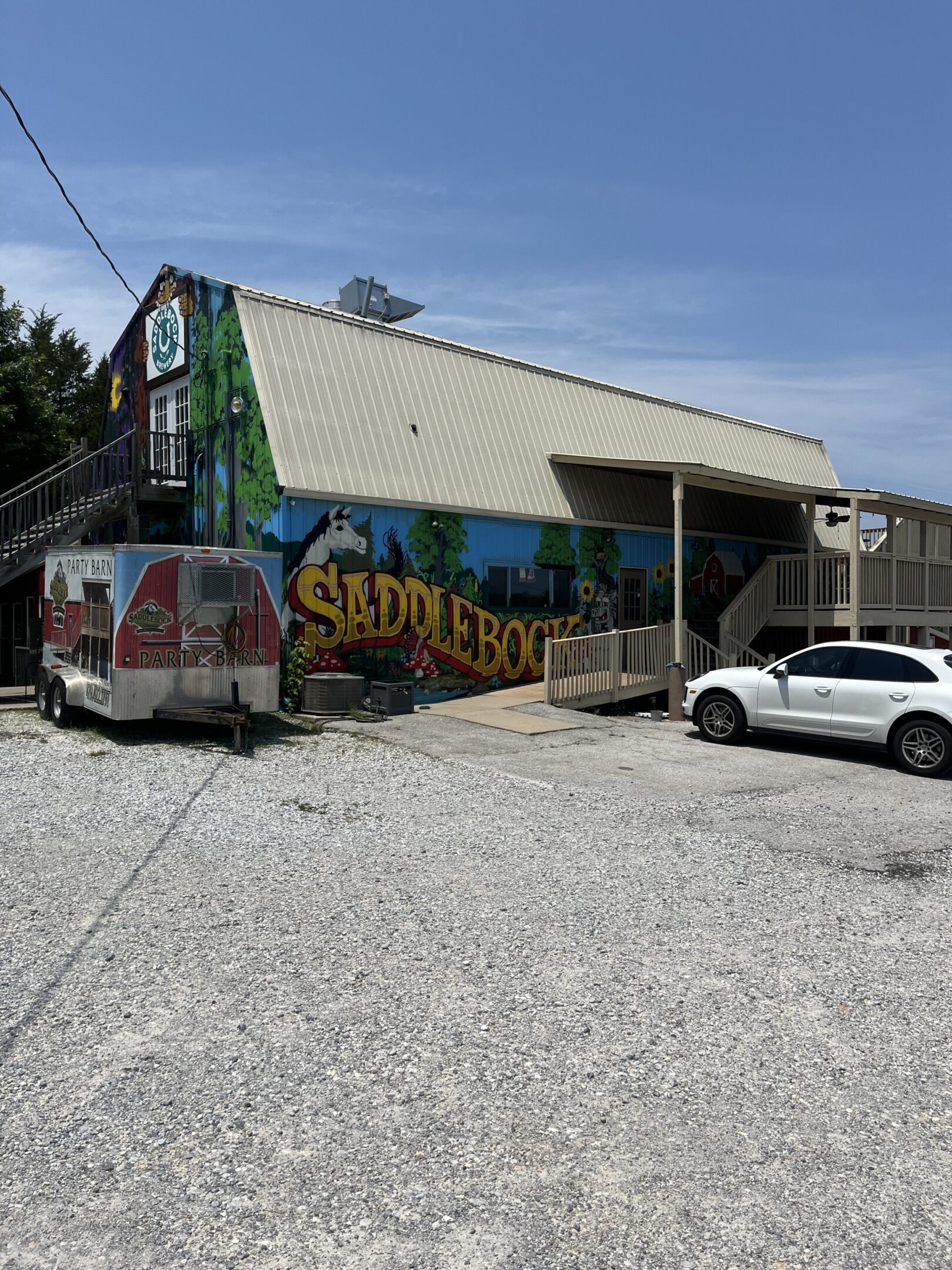 Exterior of Sadler's Brewhouse with parked vehicles.
