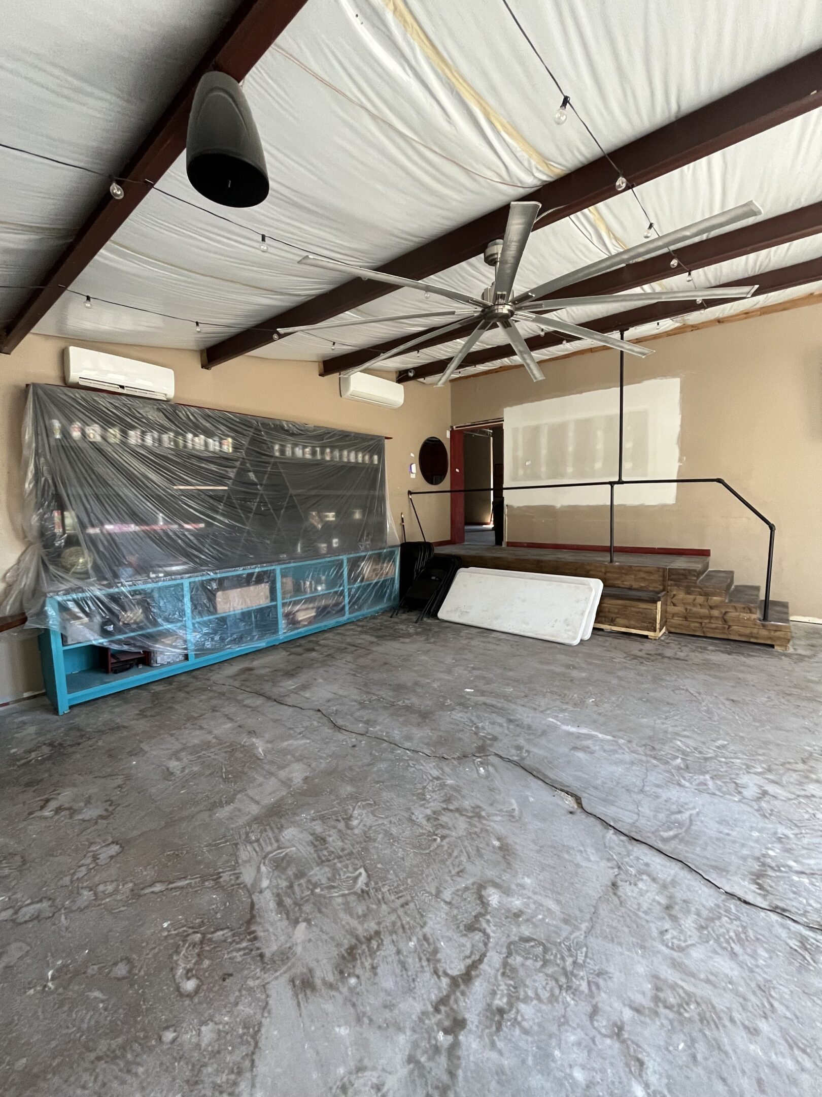 Empty room with a large industrial machine and concrete floor.