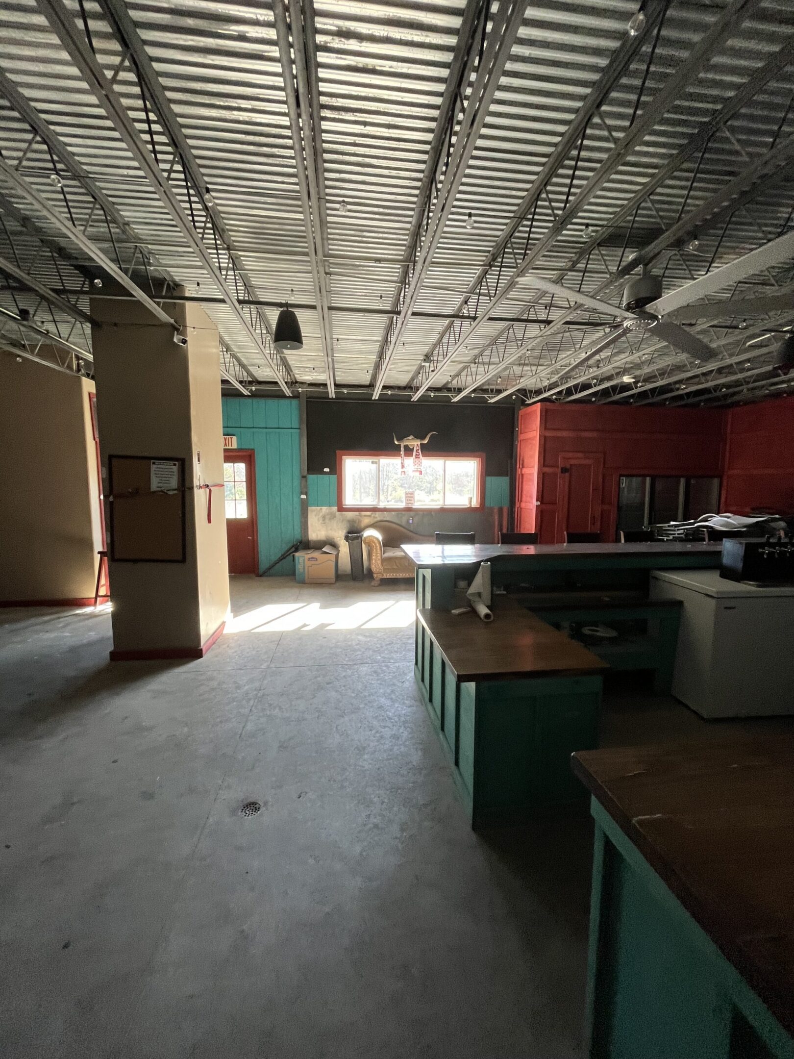 Spacious indoor area with desks and industrial ceiling.