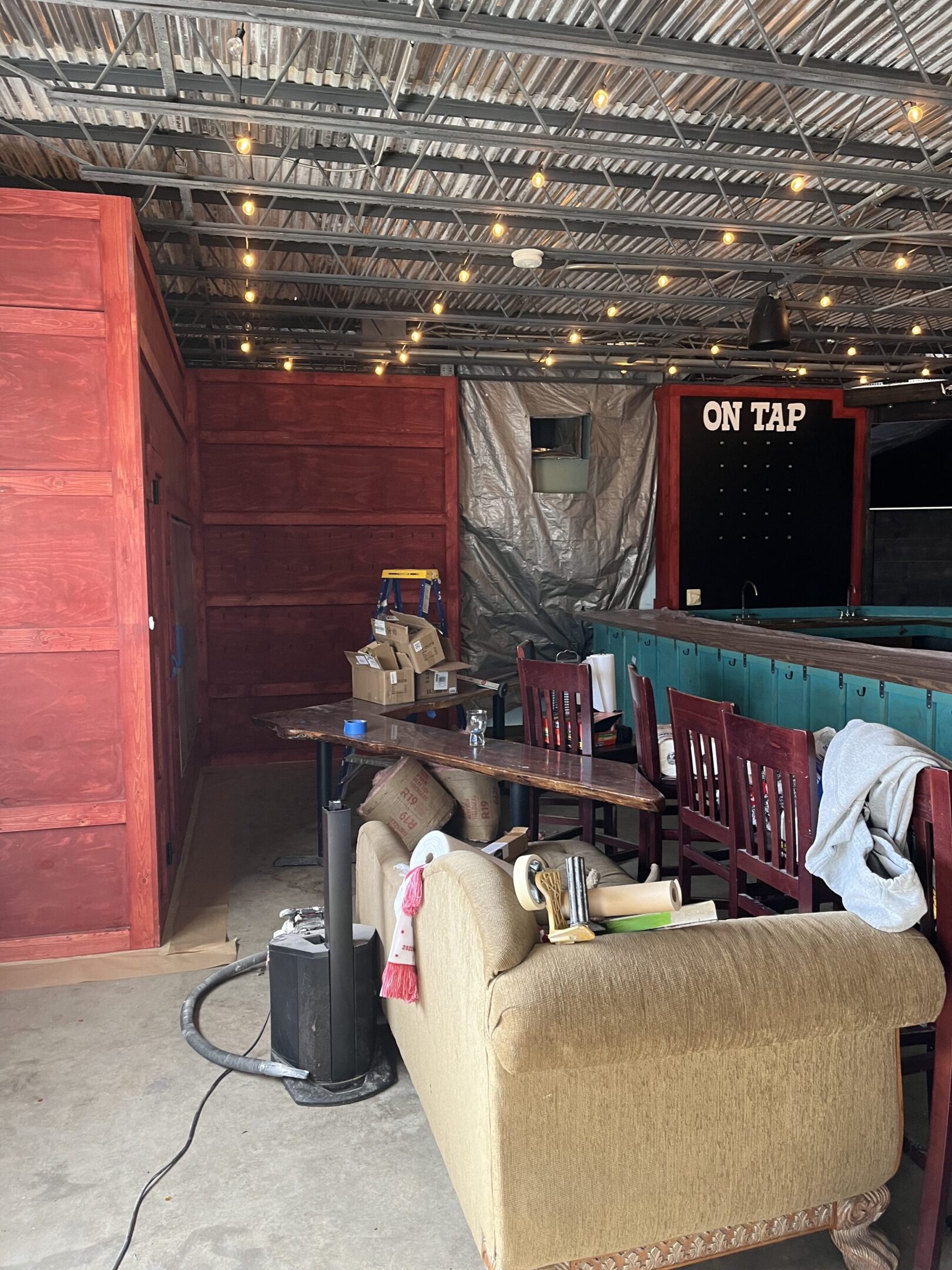 Cozy rustic bar with string lights and vintage furniture.