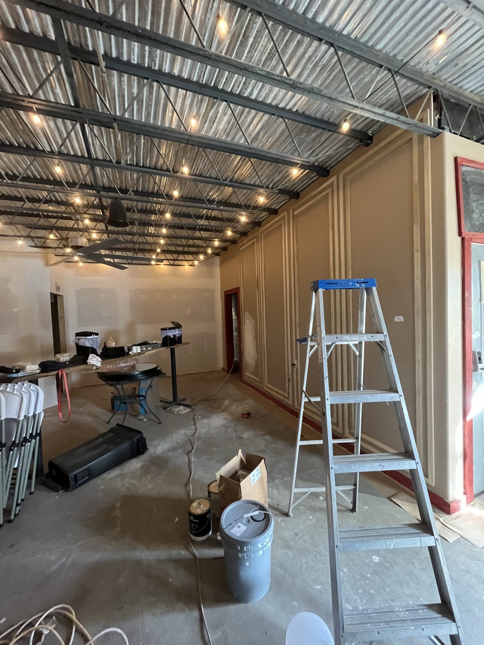 Interior of a room under renovation with tools and materials scattered.