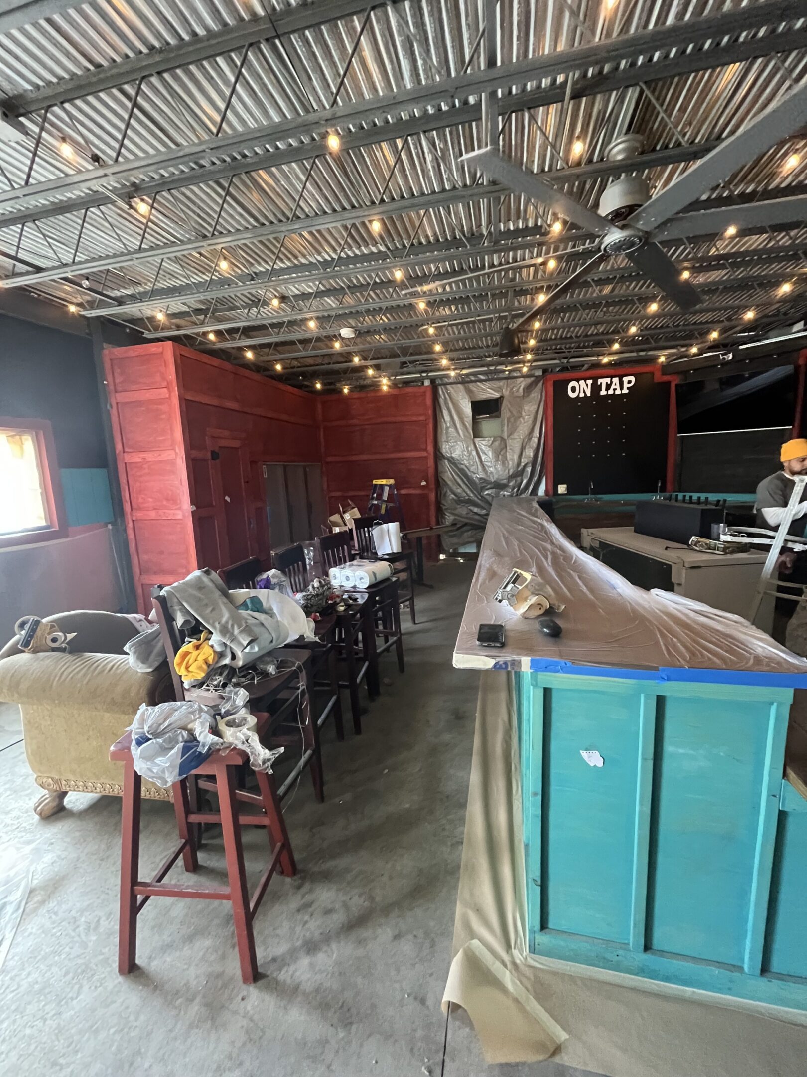 Rustic bar area with string lights and eclectic seating arrangements.