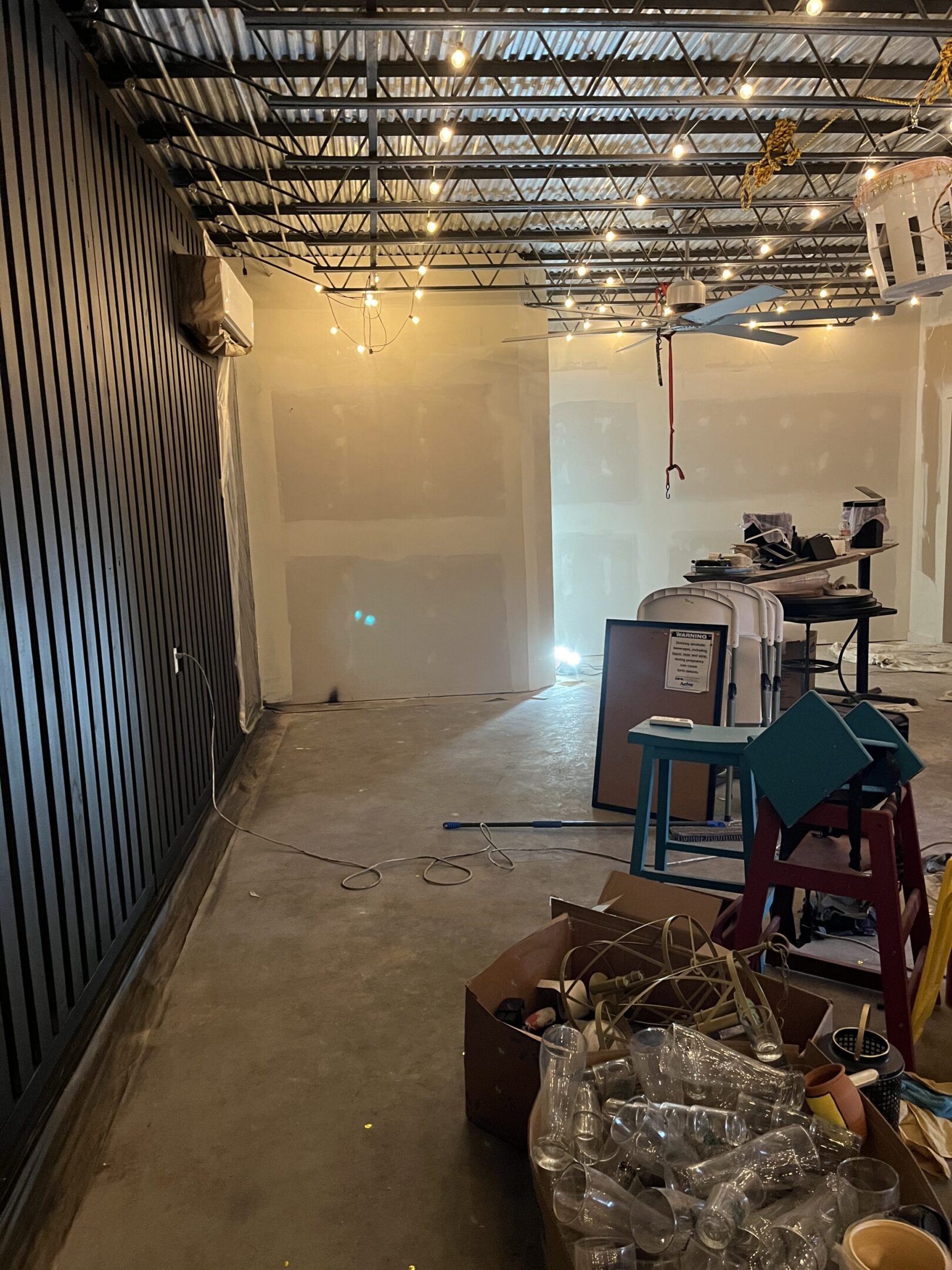 An empty industrial-style room with exposed ceiling and concrete floor.