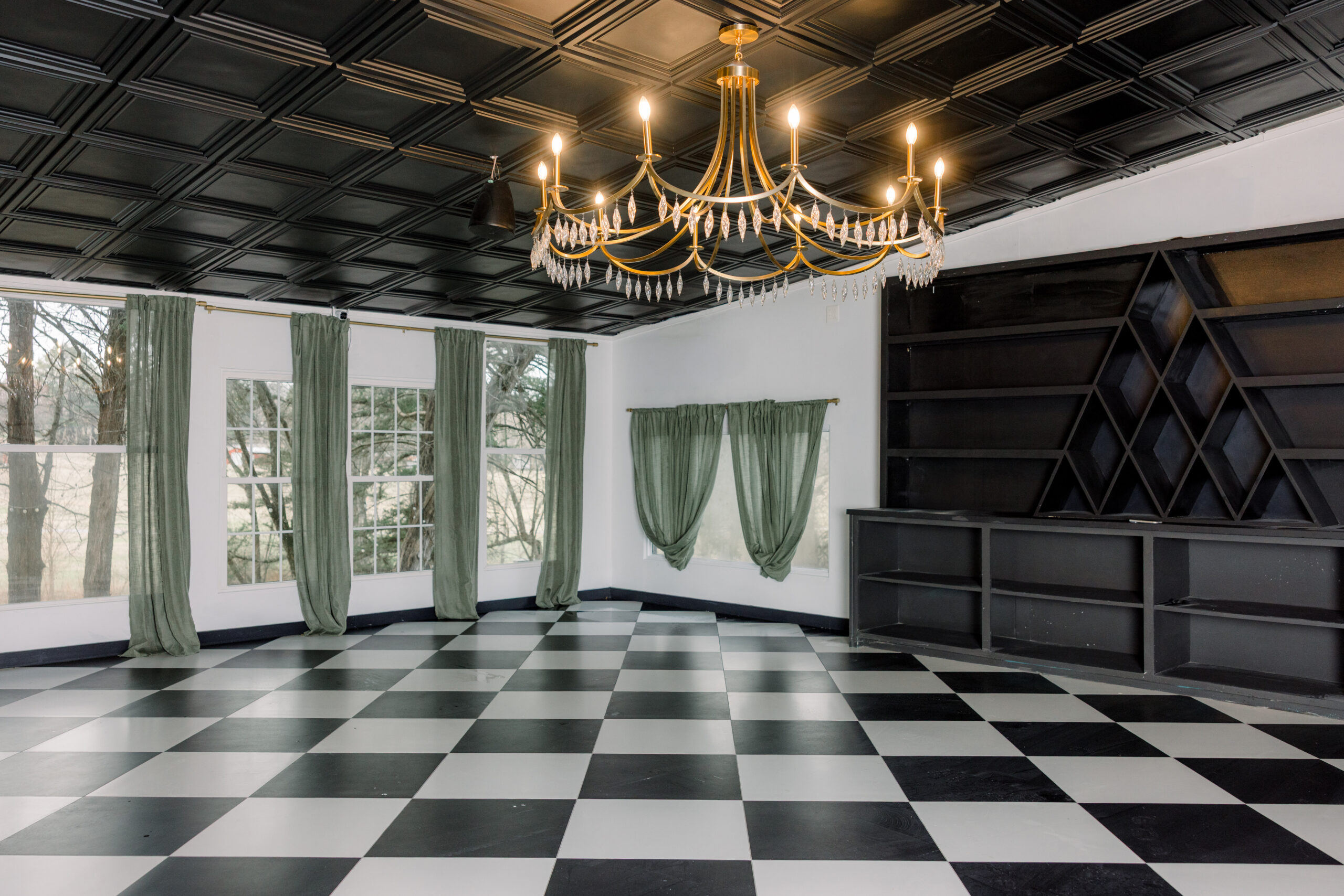 Elegant room with black-and-white checkered floor and chandelier lighting.