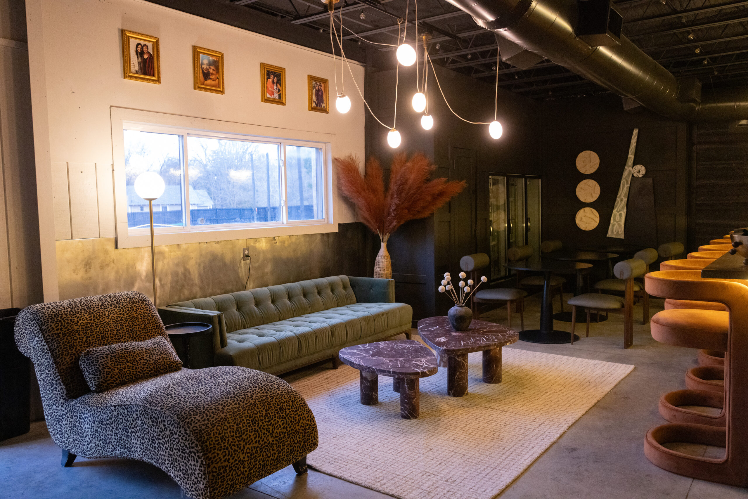 Cozy living room with modern furniture and hanging lights.
