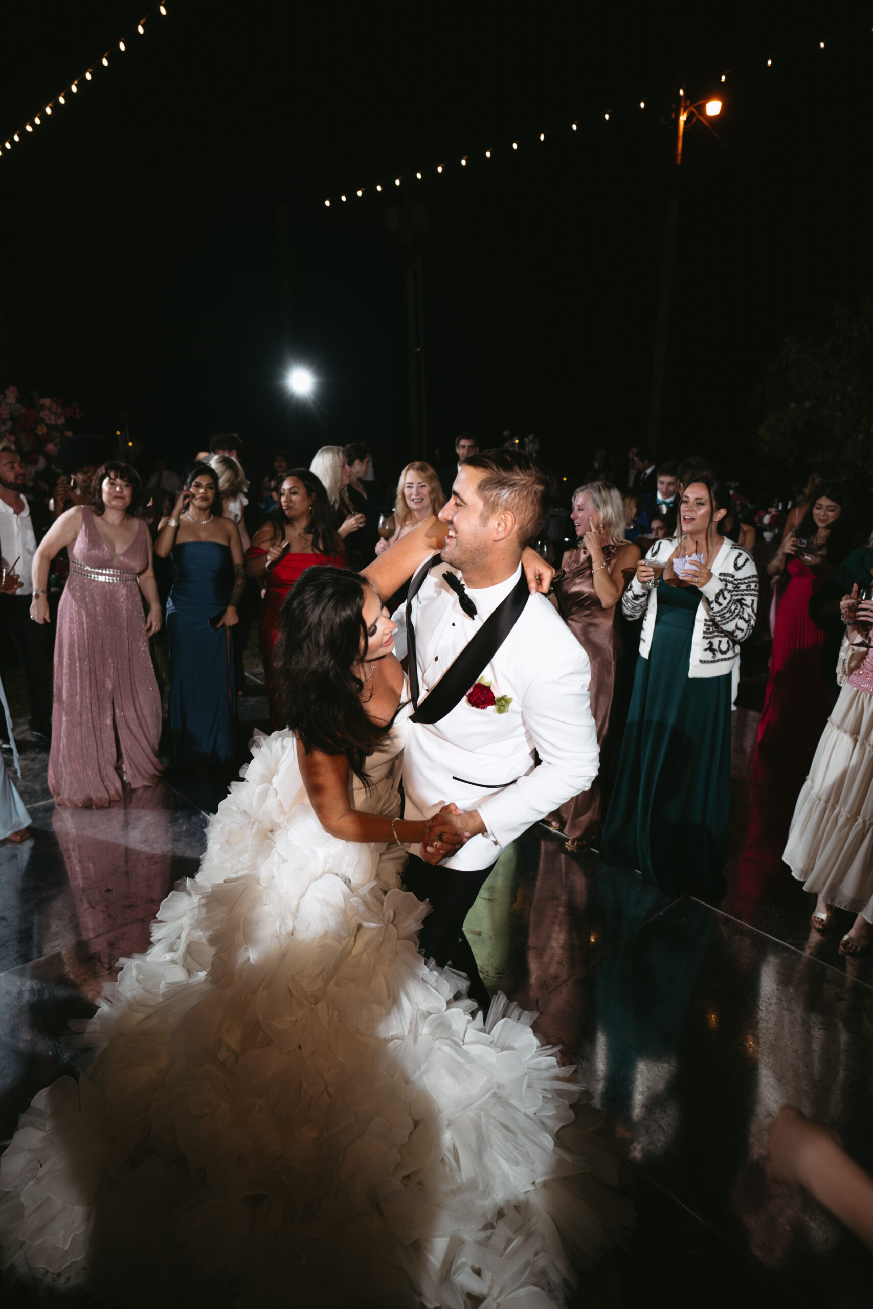 Bride playfully hugging groom at wedding reception.