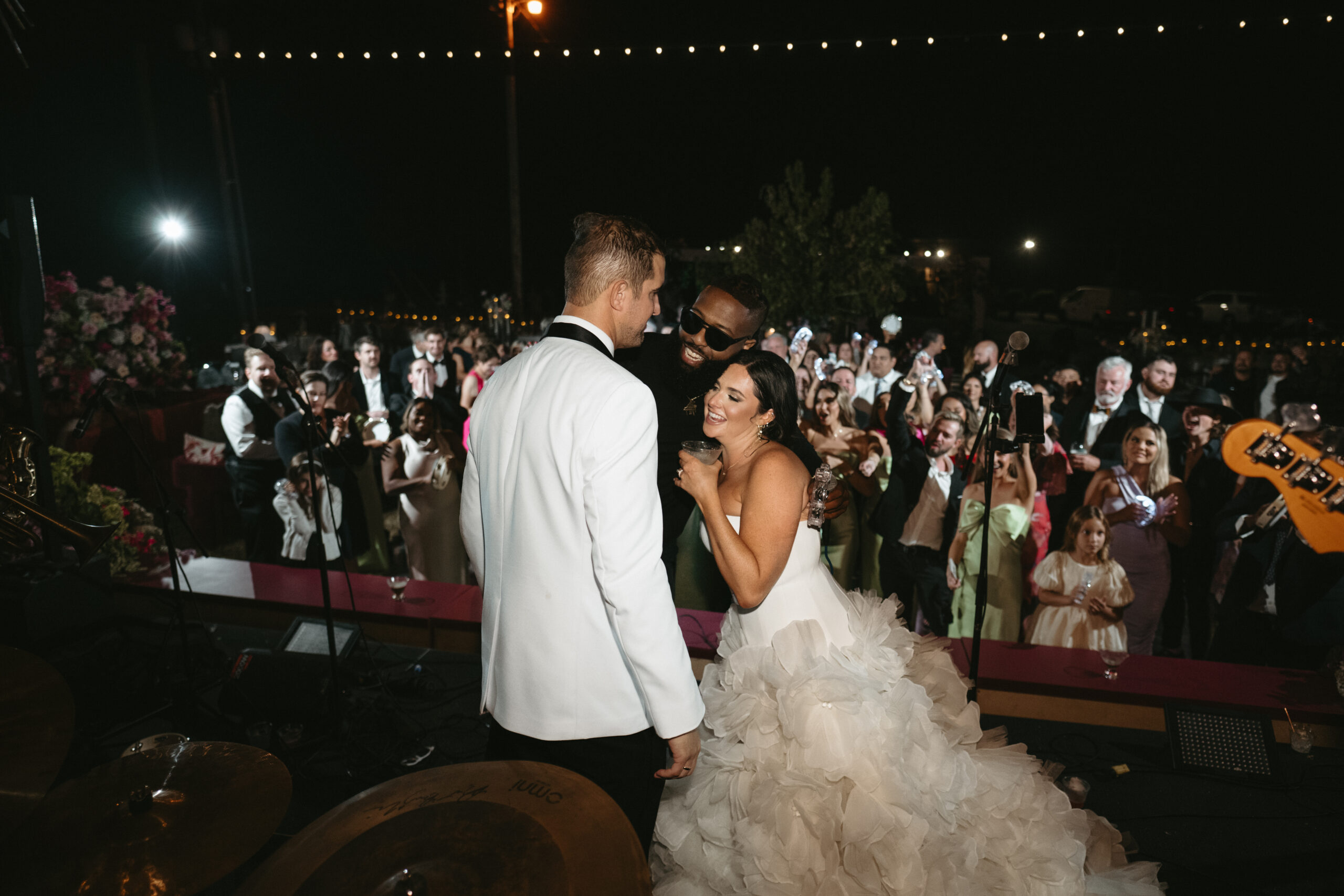 Bride and groom sharing a moment at their wedding reception under string lights.