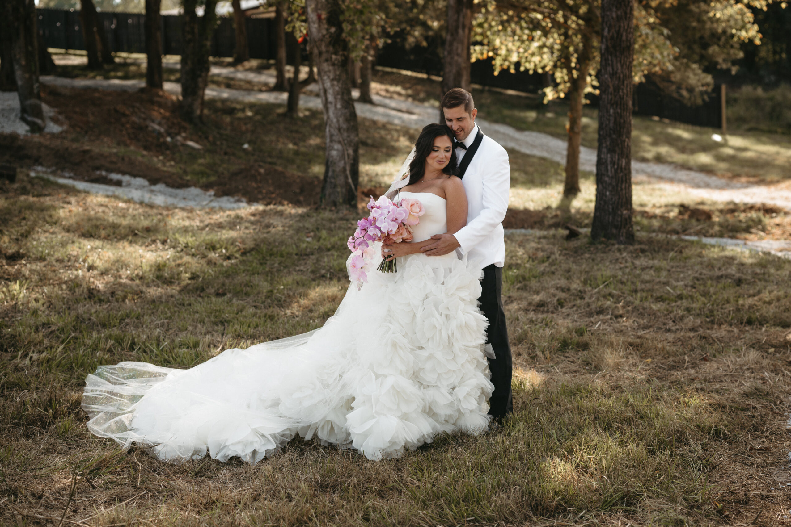 Bride and groom posing outdoors on their wedding day.