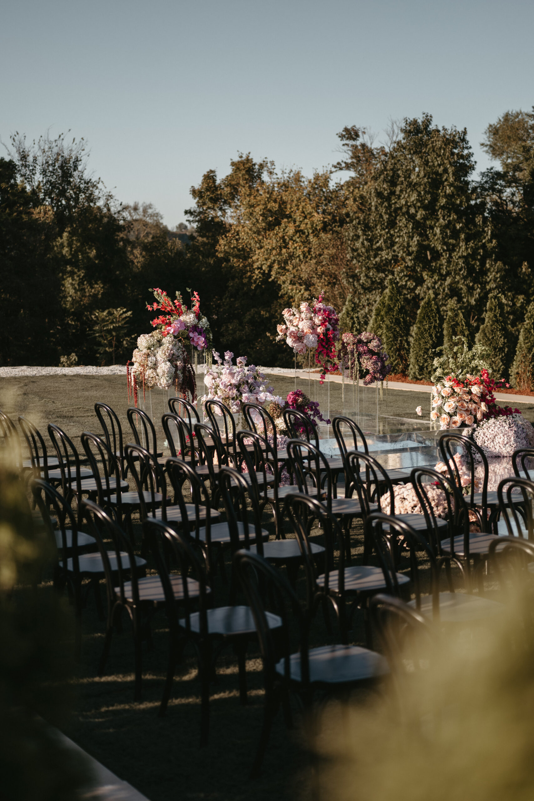 Outdoor wedding ceremony setup with floral decorations and chairs.