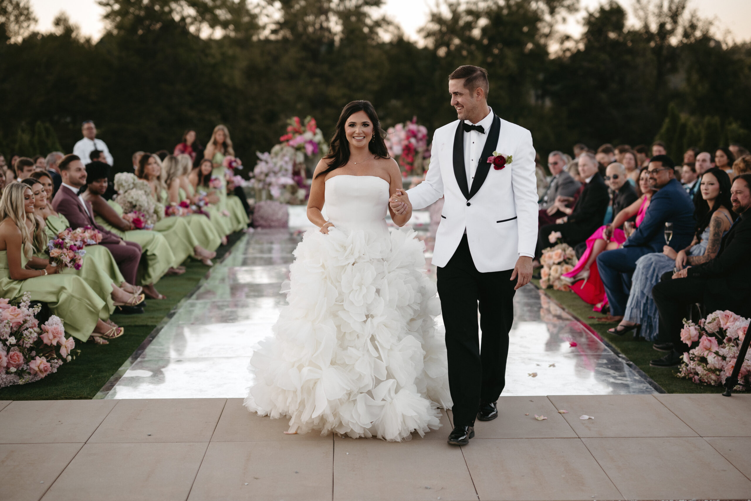 Bride and groom walking down the aisle at an outdoor wedding.