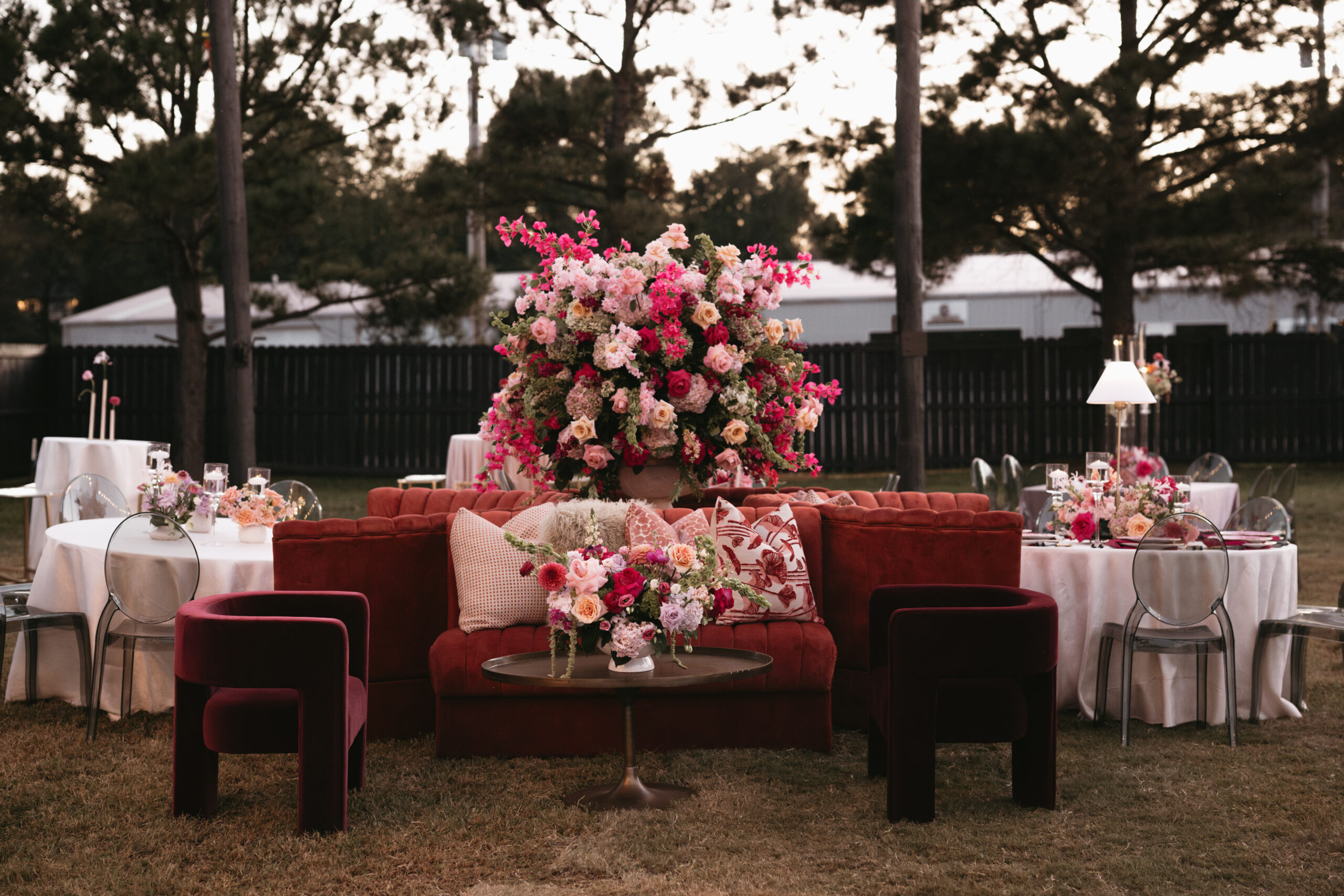 Elegant outdoor floral centerpiece with vibrant pink and white flowers on a wooden table.